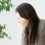 吐き気の症状が出ている女性